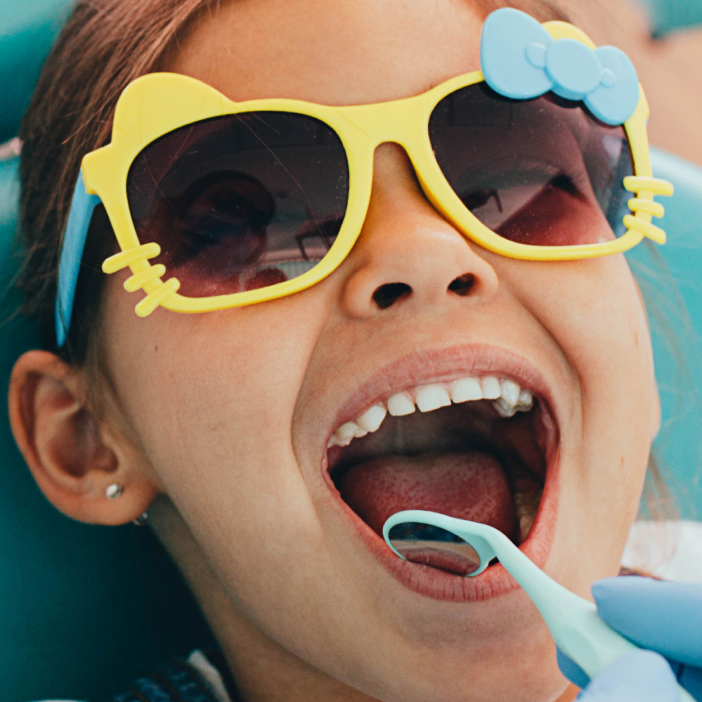 Smiling kid with sun glasses at the dentist